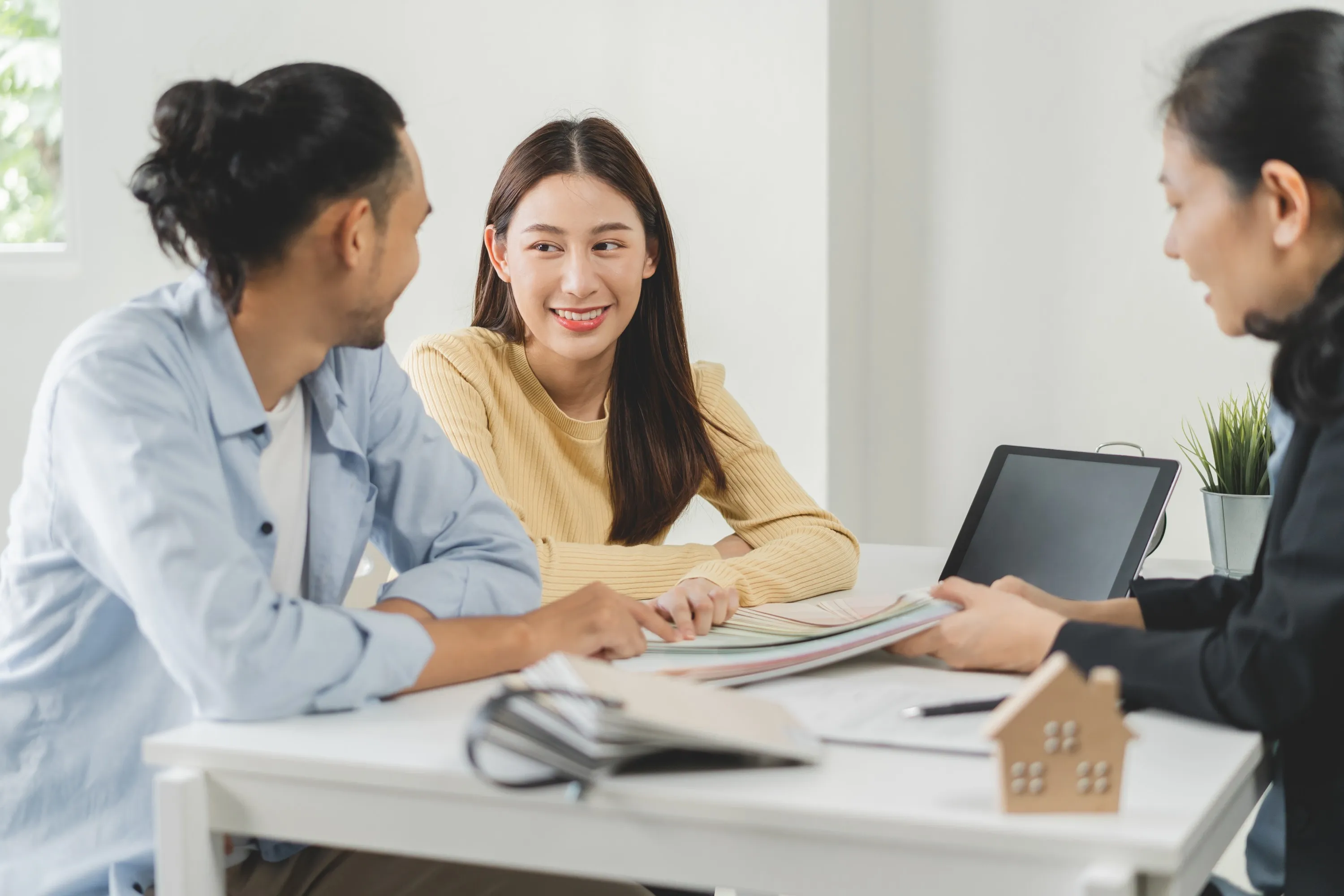 happy asian couple client people choose color palette chart swatch paint wall new home with designer woman office desk material interior design Horizontal