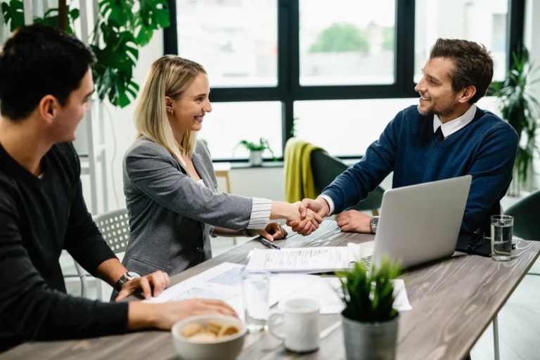 young happy couple meeting with financial advisor office woman is handshaking with agent Horizontal